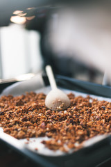 muesli maison et cuillère en bois sur une plaque de four