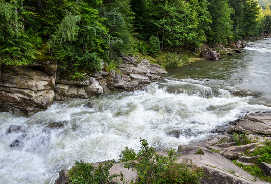 Fast Powerful flow of waterfall Probij on Prut river on a background of forest. This tourist attraction famous resort city in western Ukraine in the Carpathian mountains