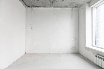 interior of a new apartment without finishing in gray tones with electrical wiring