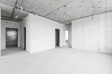 interior of a new apartment without finishing in gray tones with electrical wiring