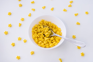 a bowl of cornflakes stars for Breakfast with love. plate with cornflakes top view.