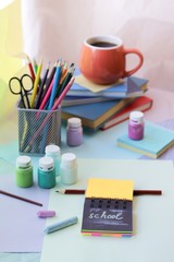 School stationery, books, cup of tea on the table, home schooling concept, part of the interior children's room, back to school