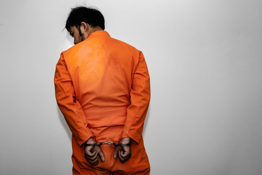 Prisoner in orange robe concept,Portrait of asian handsome man in Prison uniforms,Bandit has a lot of muscle,