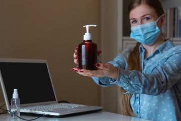 Way to keep it safe. Young woman disinfecting gadgets surfaces on her workplace. Working out with laptop, smartphone, using sanitizer. Prevention against pneumonia, COVID-19 spreading, protecting.