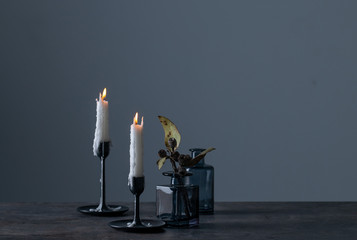 Lighted candles and vases on table.