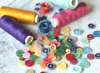 Sewing accessories and accessories for needlework. Reels of thread, pins, buttons, ribbons on white boards background. Copy spase. Sewing, embroidery, craft, sewing courses, Training.