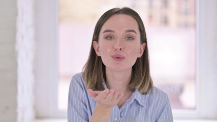 Fototapeta premium Portrait of Attractive Young Woman Giving Flying Kiss
