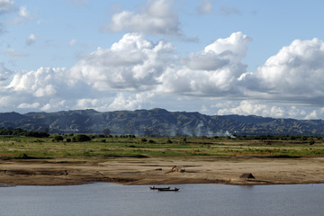 Authentic landscape in Myanmar (Burma). Boats on the river in the foreground, mountains in the background. Travel Asia.