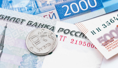 one russian ruble coin on russian rubles banknotes closeup