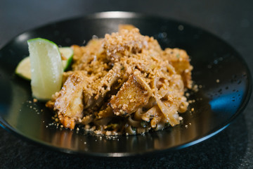 Noodle dish with tofu peanuts and lime prepared by a chef in a restaurant