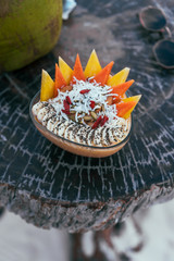 Smoothie bowl in a wooden plate with coconut and fruit