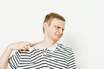 Closeup portrait of young man opening shirt to vent,it's hot. Negative emotion, facial expression,...