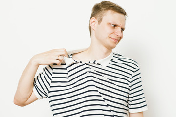 Closeup portrait of young man opening shirt to vent,it's hot. Negative emotion, facial expression,...