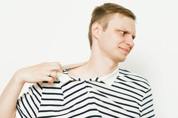 Closeup portrait of young man opening shirt to vent,it's hot. Negative emotion, facial expression,...