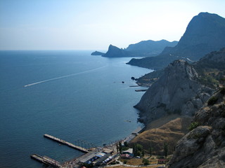 The high rock mass of the coastal mountains forms an uneven coastline of the sea.