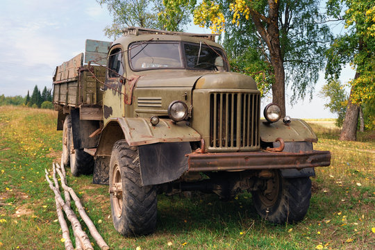 An old cargo all-terrain vehicle with a vintage and brutal appearance, stands in an autumn field.