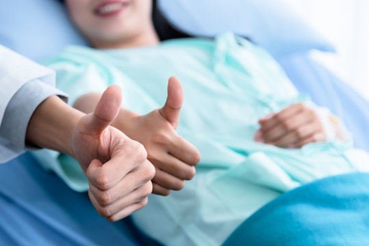 Blurred soft images of Doctor and female patients Raise they hand to make a great symbol, because of successful treatment, to health care people and health insurance concept.
