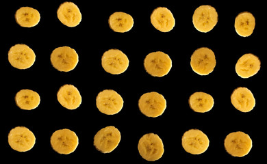 Many pieces of banana isolated on a black background.