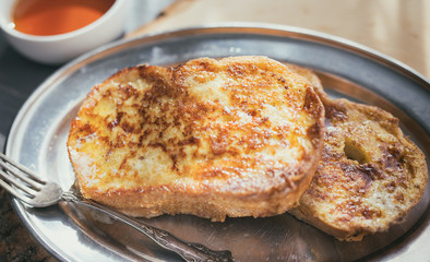 Two pieces of French of toast on a silver tray with antique fork. 