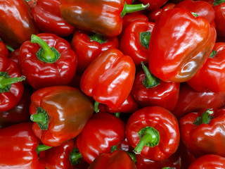 Fresh red bell pepper in market, healthy food. Bright sweet red pepper, top view, natural background