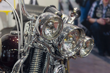 Headlights and chrome-plated motorcycle elements close up. Transport