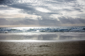 Fototapeta na wymiar Cloudy Blue Sky with Rays of Sun Lights on a Beach