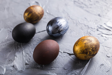 Holidays, traditions and Easter concept - Dark stylish easter eggs on grey background.