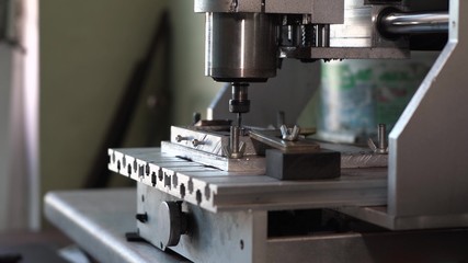 The CNC machine works and cuts the item out of wood. Digital computer machine engrave icon on black metal.