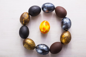 Holidays, traditions and Easter concept - Dark stylish easter eggs on white wooden background.