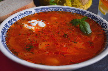 Traditional Russian and Ukrainian borsch, red soup with bread on a dark background. Borsch with meat, sour cream and dill. Overhead Copy Space