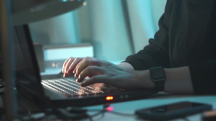 Close up footage of woman hacker hands printing on laptop, then we see her face. She is happy because she broken into system