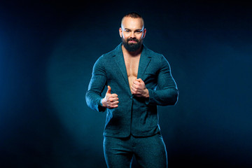 Portrait of handsome stylish man bodybuilder with naked torso in elegant suit