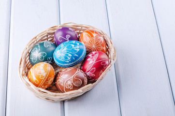 Variety of colorful handmade scratched easter eggs on wooden table