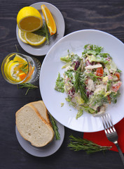 Salad with radishes, lettuce and cherry tomatoes seasoned with diet yogurt. Vitamin spring salad of fresh vegetables. Top view and side view.