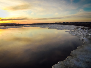 beautiful sunset over the spring river opened from ice