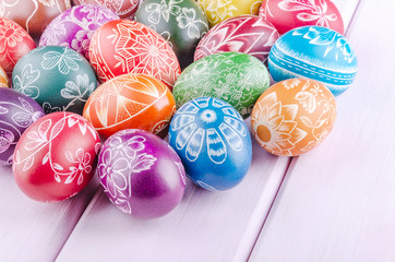 Fototapeta na wymiar Variety of colorful handmade scratched easter eggs on wooden table