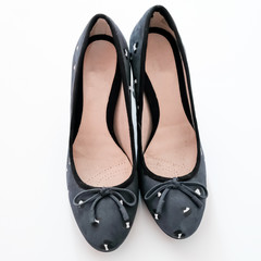 Front on view of a pair of ladies dark navy patterned heeled shoes on a plain white background