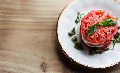 Overhead view of a caprese salad, garnished with fresh picked basil. 