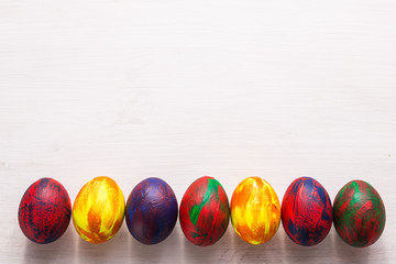 Holidays, traditions and Easter concept - Multi-colored decorative colourful eggs on white background with copy space. Top view.