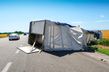Consequence of an accident on the road. Inverted truck on the highway.