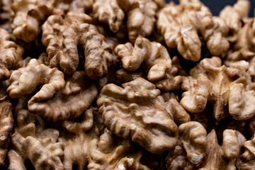 Big walnuts pile close-up. Walnut kernels background. Selective focus.