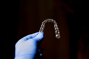 hand holding transparent dental aligner