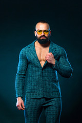 Portrait of handsome stylish man bodybuilder with naked torso in elegant suit