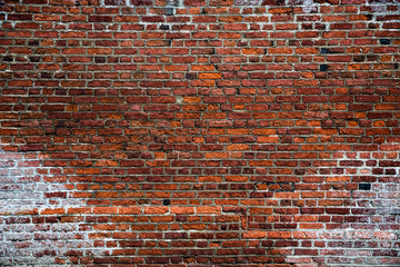 A rustic and textured, full frame brick wall background that is textured, worn, weathered, old, vintage and rough with a grunge look and copy space