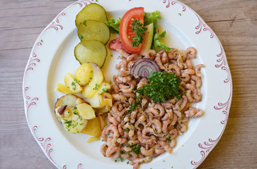 north sea crabs with fried potatoes and parsley garnish, the aromatic seafood is a typical delicacies on the coast in friesland, northern germany, high angle view from above