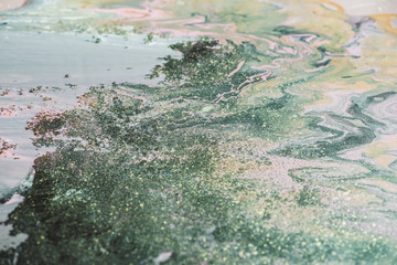 Fantasy fluid art background with dark green, orange and pink tints. Dirty marble effect of acrylic paints. Chaotic liquid ink of oxide tones. Toxic surrealistic abstract texture with mix marsh colors