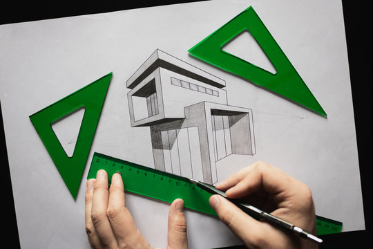 Dibujando una casa moderna en perspectiva cónica con dos puntos de fuga con escuadra y cartabón de color verde sobre un escritorio negro