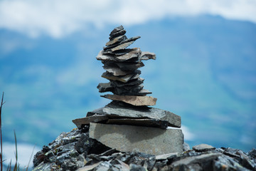 pile of rocks superimposed on the top of a mountain with the bottom out of focus, a rock on another...