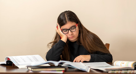 13 years old girl doing homework at home