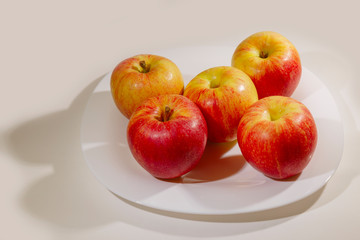 The apples are on a plate on the table.